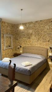 恩纳Agriturismo Borgo Furma的一间卧室设有一张床和石墙