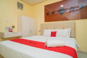 KandangsapiRedDoorz Plus Syariah near Pasar Turi的卧室配有一张大白色床和红色毯子