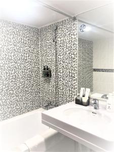 台南河乐文旅的白色的浴室设有水槽和淋浴。