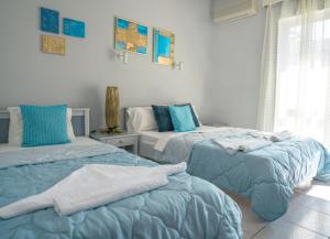 阿默达拉-伊拉克利翁RODI BLUE appartments的两张睡床彼此相邻,位于一个房间里