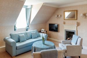 卡伦德罗马营乡间别墅酒店的客厅设有蓝色的沙发和壁炉
