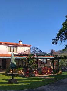 马尔帕尔蒂达德普拉森西亚Casa Rural del Corral的庭院配有遮阳伞和桌椅。