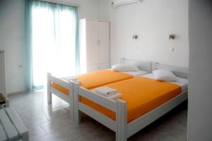 伊奥斯乔拉Ios Penelope的一间卧室配有带橙色床单的床和窗户。