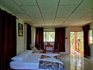 伊基托斯Milía Amazon Lodge的卧室配有床、桌子和窗户。
