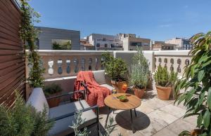 巴塞罗那Hotel Casa Sagnier的小阳台,配有桌子和盆栽植物