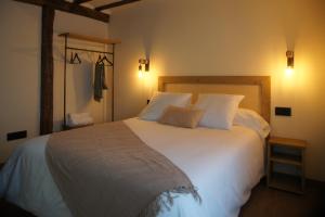 圣米良德拉科戈利亚Fábrica de Harinas La Gloria的卧室配有一张带两个枕头的大白色床