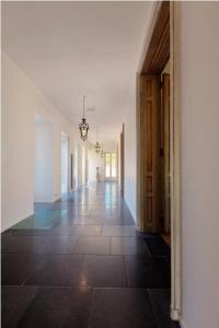 卡尼B&B Domaine Villa Bayard的一间房屋的空走廊,铺着瓷砖地板