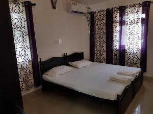 比纳里姆ARY Royal Palms - 1 BHK的窗帘间的床和毛巾
