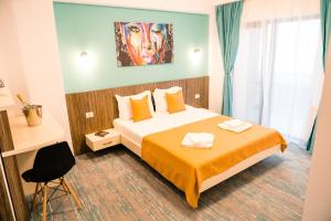 北马马亚-讷沃达里Vila GRANDE MAMAIA NORD的酒店客房设有一张床,墙上挂有绘画作品