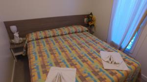 维耶斯泰Villaggio Santo Stefano的一间小卧室,配有一张床和一张桌子及两条毛巾