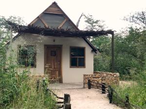 DeteGwango Heritage Resort的一间白色的小房子,设有木门