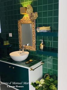 阿马兰特Quinta D`Manuel Maria- Rural Charm Houses的绿色瓷砖浴室设有水槽和镜子