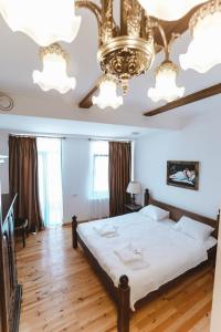 库塔伊西Hotel Verdzi的一间卧室配有一张大床和一个吊灯。