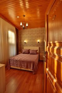 比于卡达Mimoza Butik Otel Buyukada的一间卧室设有一张床和木制天花板