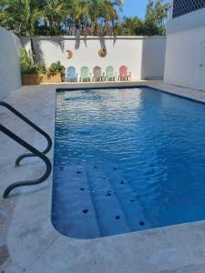 圣胡安Sea breeze vacation ll en Condominio Verde Mar的游泳池拥有蓝色的水和色彩缤纷的椅子