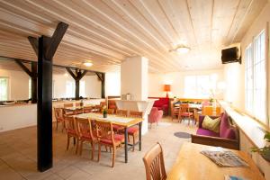 林道Hostel Westküste的餐厅设有木制天花板和桌椅