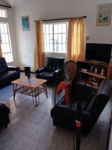 卡特勒博尔纳Ken Villa的客厅配有沙发、椅子和桌子