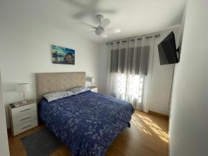 圣米格尔德阿沃纳Vacacional Arbelo Golf的一间卧室配有一张床和吊扇