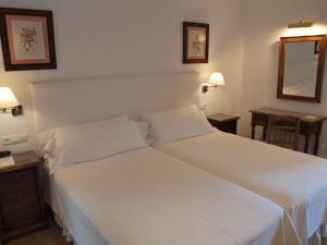 贝瑙汉圣莫利诺酒店的一张大白色的床,位于带两张桌子的房间