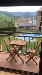 索特Precioso apartamento con piscina, ideal familias!的一个带游泳池的阳台,配有一张野餐桌和两把椅子