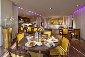 布拉迪斯拉发Clarion Congress Hotel Bratislava的用餐室配有餐桌和食物