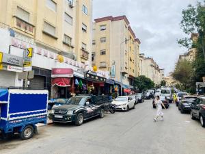 丹吉尔Big appartment near soccer stadium in Tangier的一名妇女沿着城市街道停车,