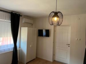 Ščitarjevo4 STARS ROOMS Near Airport的一间设有门、电视和吊灯的房间