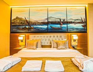 特拉布宗Aselia Hotel Trabzon的一间卧室设有一张大床,墙上挂有三幅画作