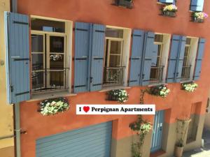 佩皮尼昂I Love Perpignan Apartments 8的建筑的侧面有蓝色百叶窗