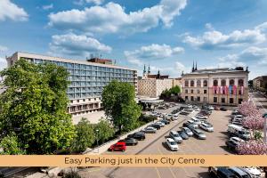 布尔诺Hotel International Brno的市中心的停车场,有车辆停放