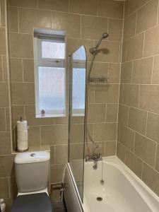 伊斯特布恩Impeccable 2-Bed Apartment in Eastbourne的带淋浴、卫生间和浴缸的浴室