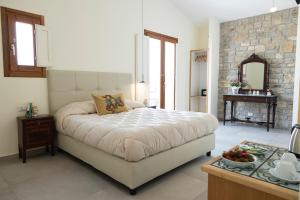 卡拉塔菲米La Corte del Sole的一间卧室设有一张大床和石墙