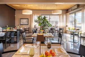 沃卡罗Conca Bella Boutique Hotel & Wine Experience的餐厅设有桌椅和窗户。