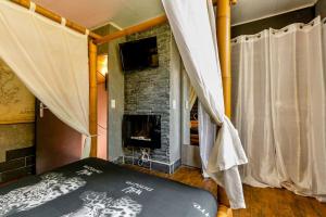 阿维尼翁Havre de paix Avignon avec Jacuzzi & Sauna的一间卧室设有壁炉和带窗帘的床