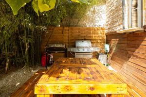 阿维尼翁Havre de paix Avignon avec Jacuzzi & Sauna的户外庭院设有木桌和烧烤架。