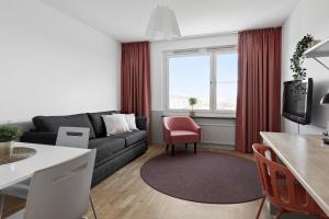 斯德哥尔摩斯德哥尔摩阿尔维克弗里农公寓式酒店的带沙发和红色椅子的客厅