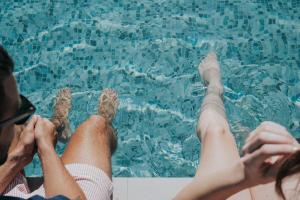 依拉佩特拉Pignolia Suites - Adults Only的坐在游泳池旁的男人和女人