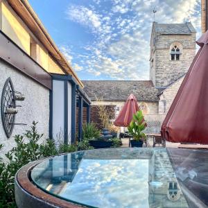 ChamouilleyAuberge du Cheval Blanc Logis的一个带游泳池和教堂的庭院