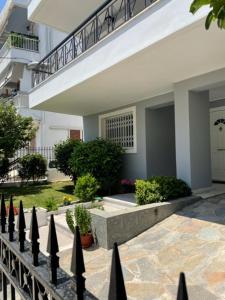 雅典Kalimera Alimos Apartment的房屋前的围栏,有楼梯
