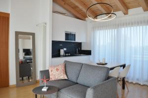 利多迪耶索罗Golf Jesolo Village ➔ Attico con Piscina的客厅配有灰色的沙发和桌子