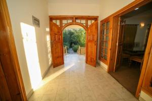 锡卡都Skardu Orchard Guest House的房屋内带木门的开放式走廊