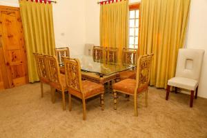 锡卡都Skardu Orchard Guest House的一间设有玻璃桌和椅子的用餐室