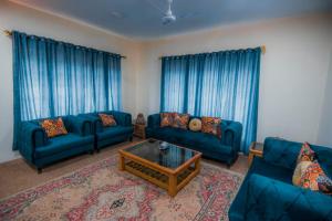 锡卡都Skardu Orchard Guest House的客厅配有蓝色的沙发和咖啡桌