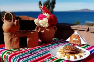 普诺Hospedaje Rural La Florida en Llachon, Titicaca的一张桌子,上面有一盘食物和一盘华夫饼