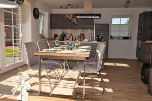 特希尔Haifisch的厨房以及带木桌和椅子的用餐室。