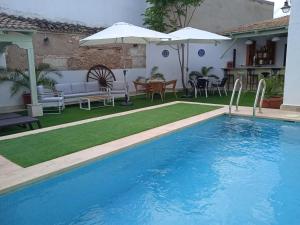 阿尔玛格鲁LA CASA DE JULIA的一个带桌椅和遮阳伞的游泳池