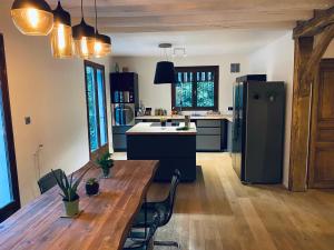 La Queue-lès-YvelinesOak'Wood的厨房配有木桌和冰箱。