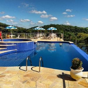 圣伊萨贝尔雷卡托阿伯纳宾馆的蓝色游泳池配有遮阳伞和椅子