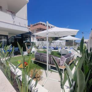 巴里里维埃拉酒店的一个带沙发和遮阳伞的庭院