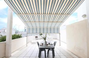 新福卡Villa Claudio by RENTHOUSESALENTO的阳台设有桌椅和天花板
